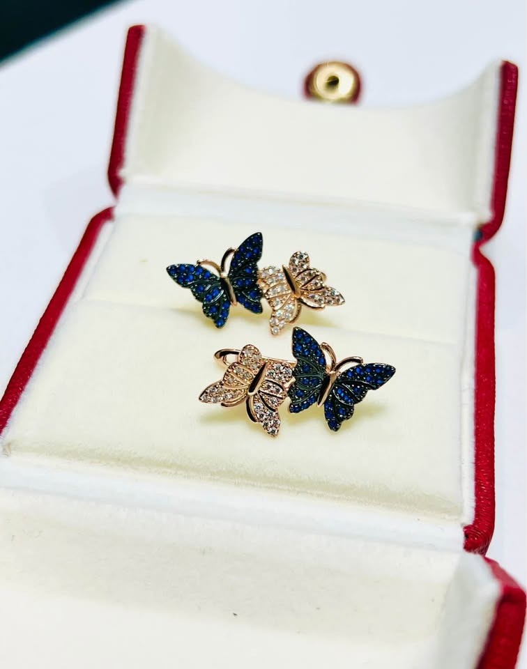 14k rolled gold butterfly earrings with blue and clear crystal wings, displayed in a red jewelry box.