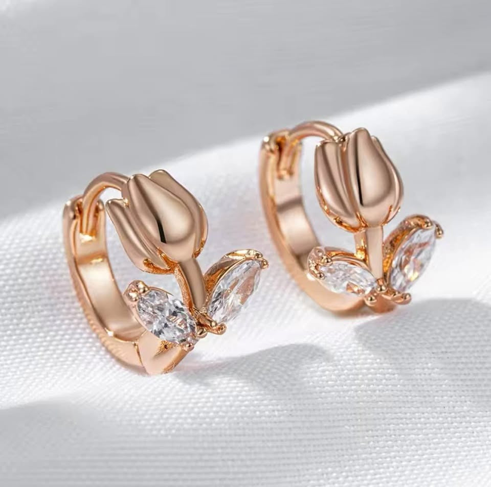 14k rolled rose gold tulip huggie earrings featuring sparkling cubic zirconia leaves.
