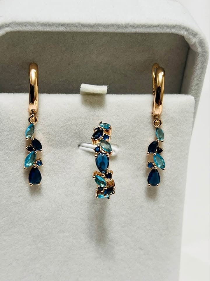 A stunning 14k rolled gold set with a ring and matching dangle earrings, featuring blue gemstones.