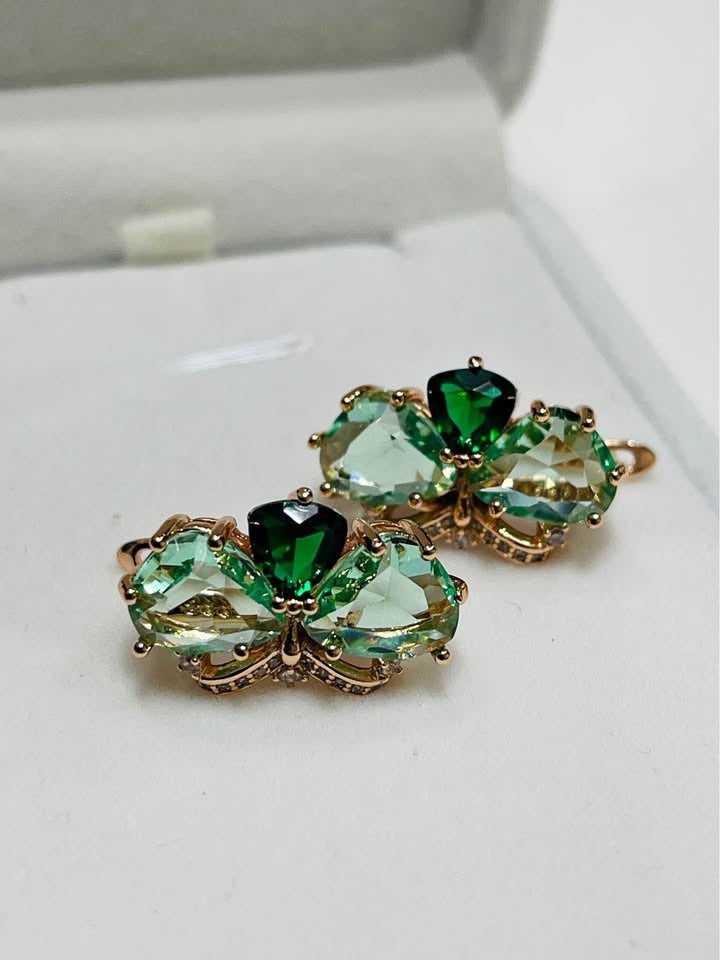 Elegant rose gold butterfly earrings featuring a mix of light and dark green gemstones for a unique look.