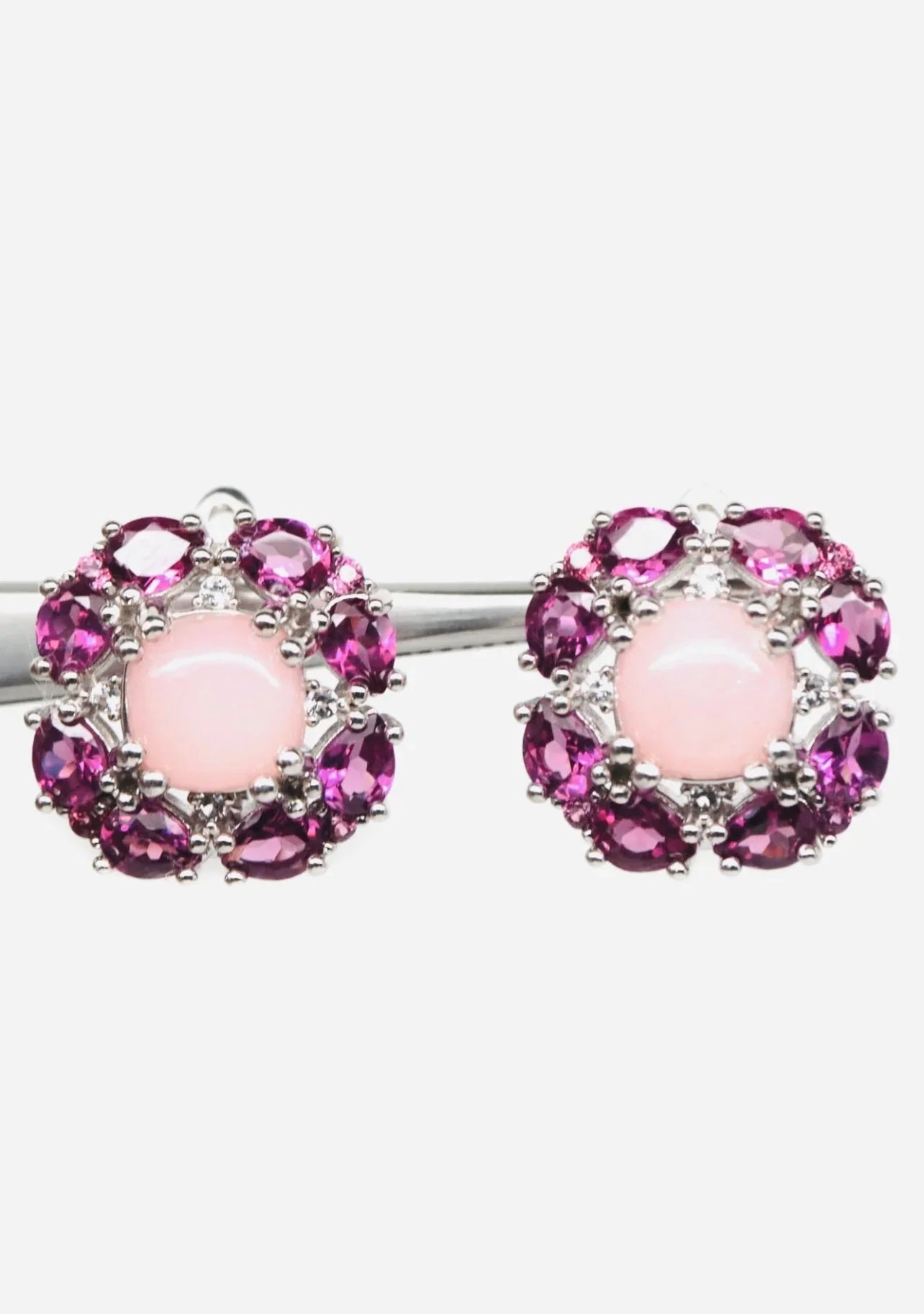 Two sterling silver flower earrings with rose quartz cabochons and rhodolite garnets.