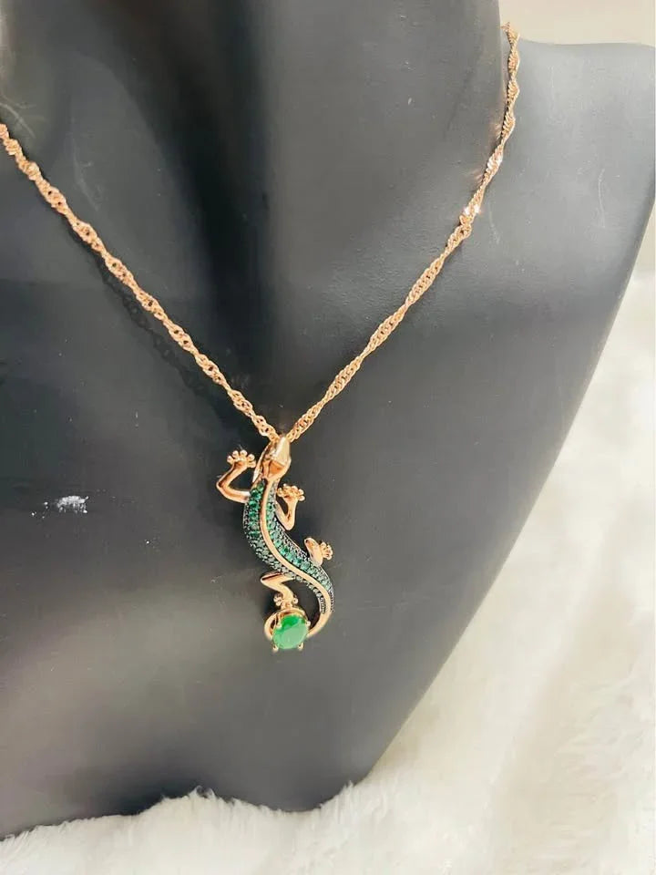Elegant rolled gold 585RG salamander pendant with green emerald, displayed on a necklace.