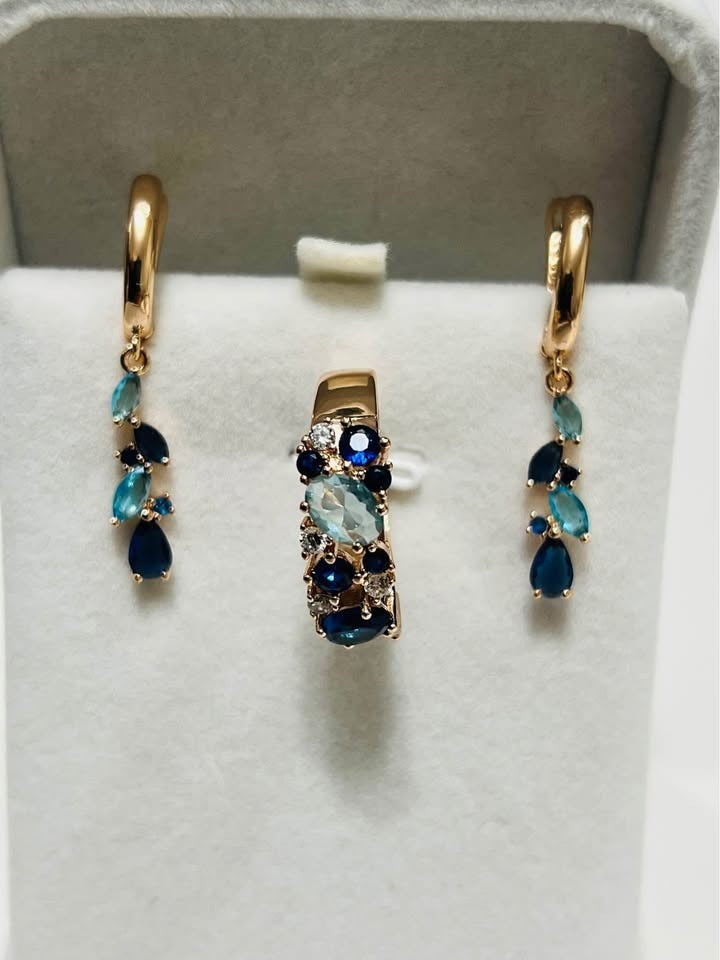 A complete set of 14k rolled gold earrings and two rings with beautiful blue gemstones.