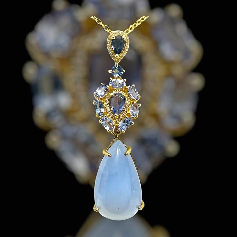 Exquisite 28ct natural tanzanite and blue sapphire 2-in-1 pendant on dark background.