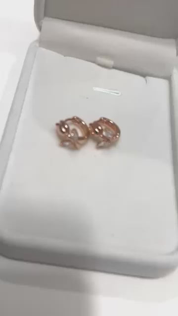 Beautiful and dainty 14k rolled gold huggie hoops featuring a unique tulip pattern and sparkling stones.