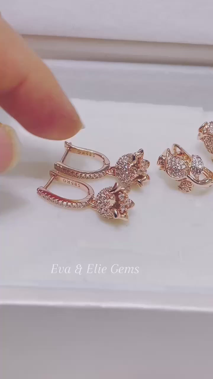 A beautiful pair of rose gold earrings with a detailed floral design.