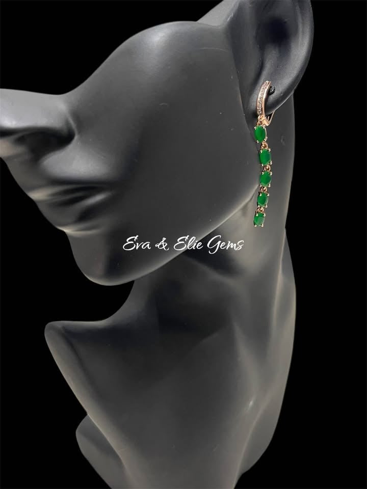 Side view of 14K 585RG emerald and diamond long fancy earrings worn on a black jewelry mannequin head.