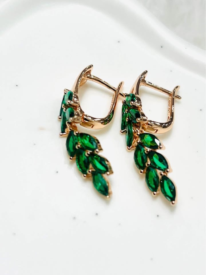 Frontal view of beautiful 14k gold-filled dangle earrings, sparkling with marquise-cut green topaz gems.