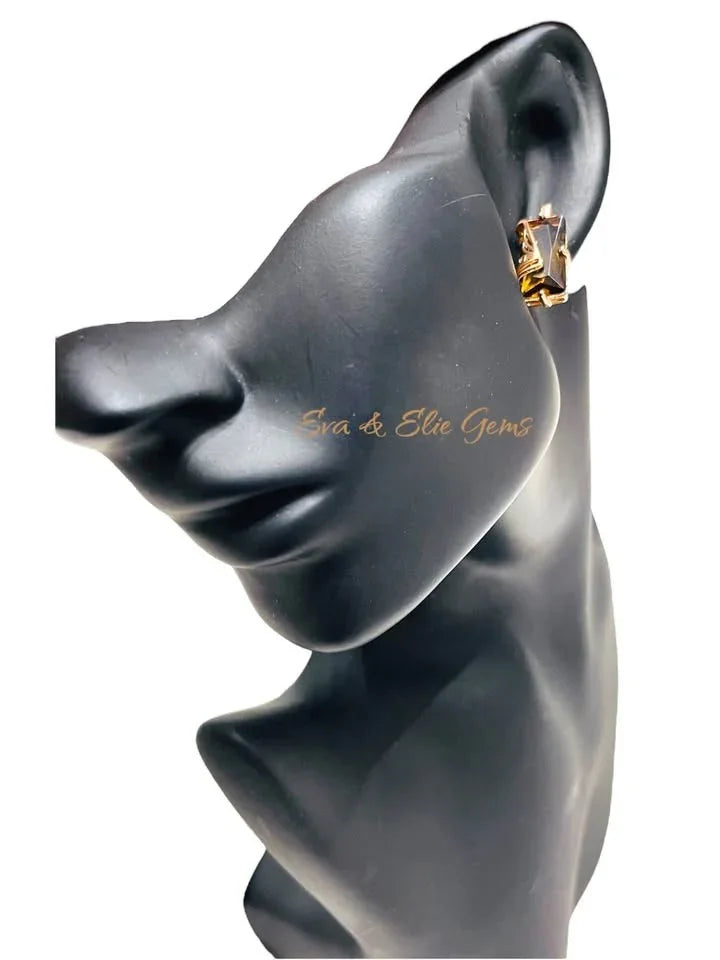 14K rolled gold citrine earring modeled on a black mannequin's ear, showing the side profile.