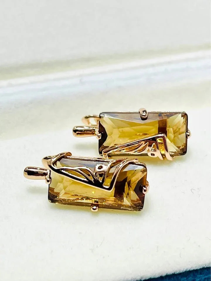 Two 14K rolled gold citrine earrings resting in an open jewelry box, ready to be worn.
