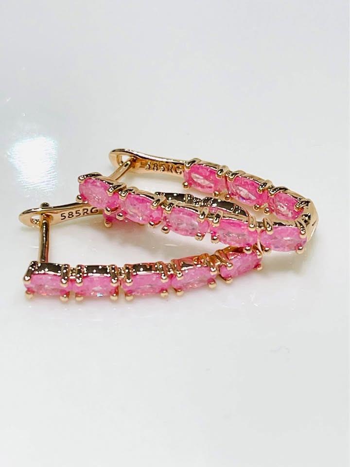 14k rose gold-filled V-shaped hoops featuring an elegant line of vibrant pink tourmaline gemstones.