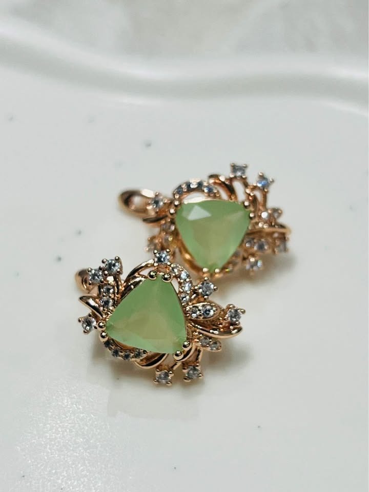 A pair of 14k rolled gold earrings featuring brilliant green prehnite stones, surrounded by sparkling cubic zirconia.
