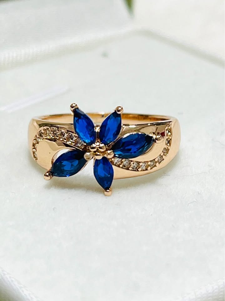 Detailed view of a 14k 585RG rose gold ring featuring a beautiful blue sapphire flower design.