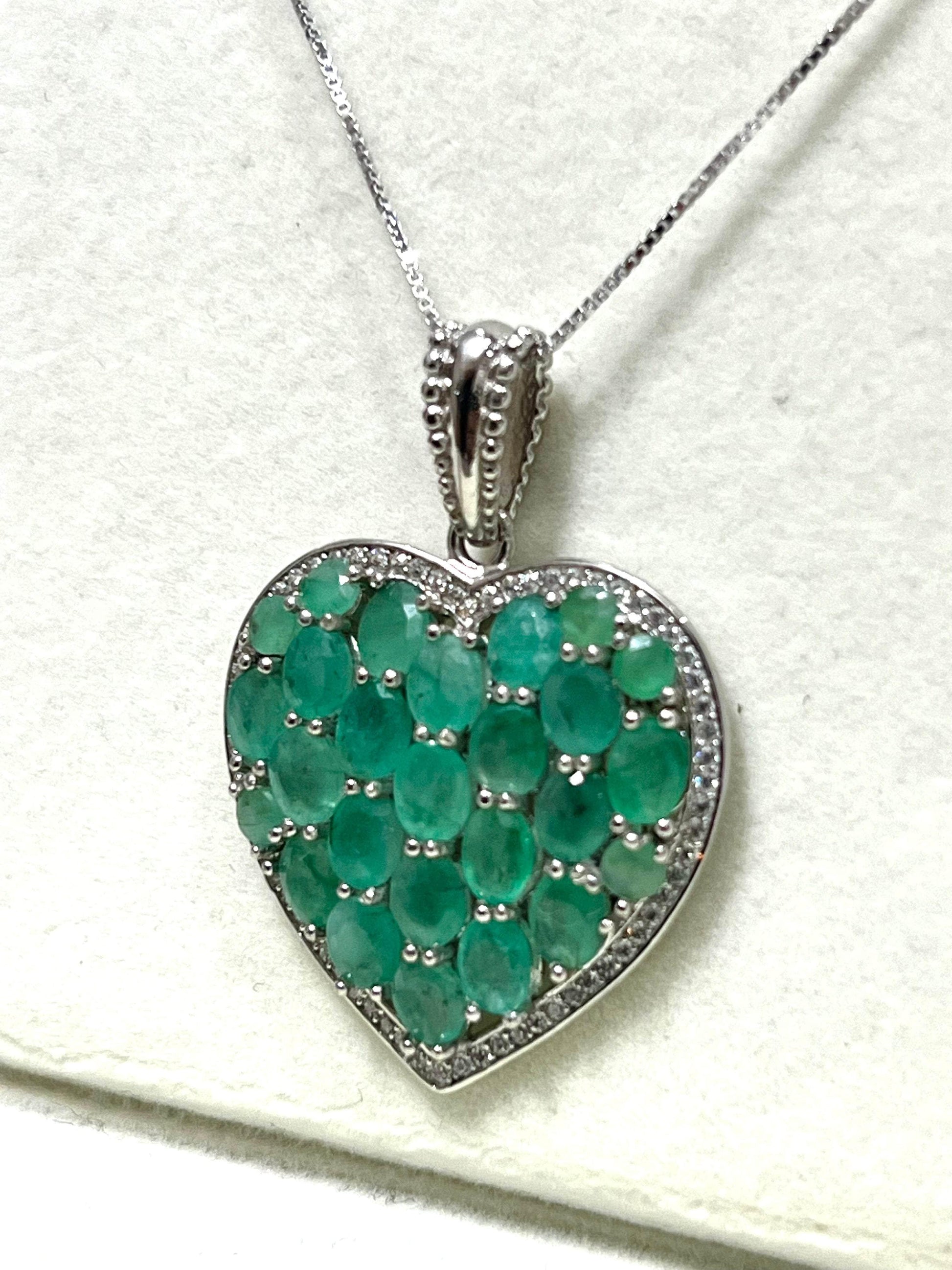 Heart pendant with sterling silver, 14K gold, Colombian emeralds, and I1 diamonds.