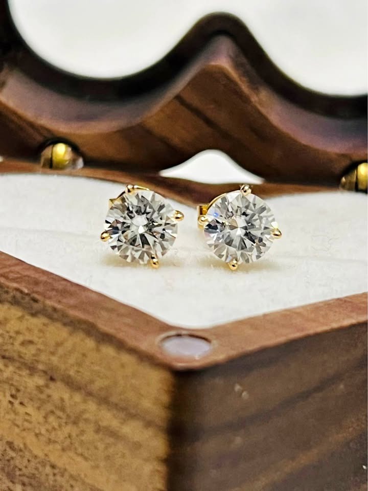 Pair of stunning 14k yellow gold Moissanite stud earrings displayed beautifully in a wooden case.