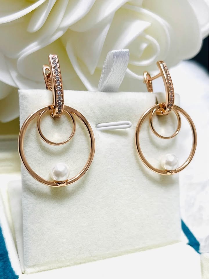 Angled shot of chic 14k gold filled double hoop earrings featuring a freshwater pearl.