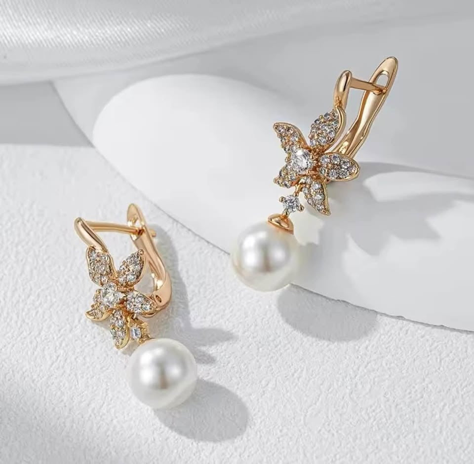 Angled view of elegant 14K gold flower earrings with dazzling pave accents and lustrous pearl drops.