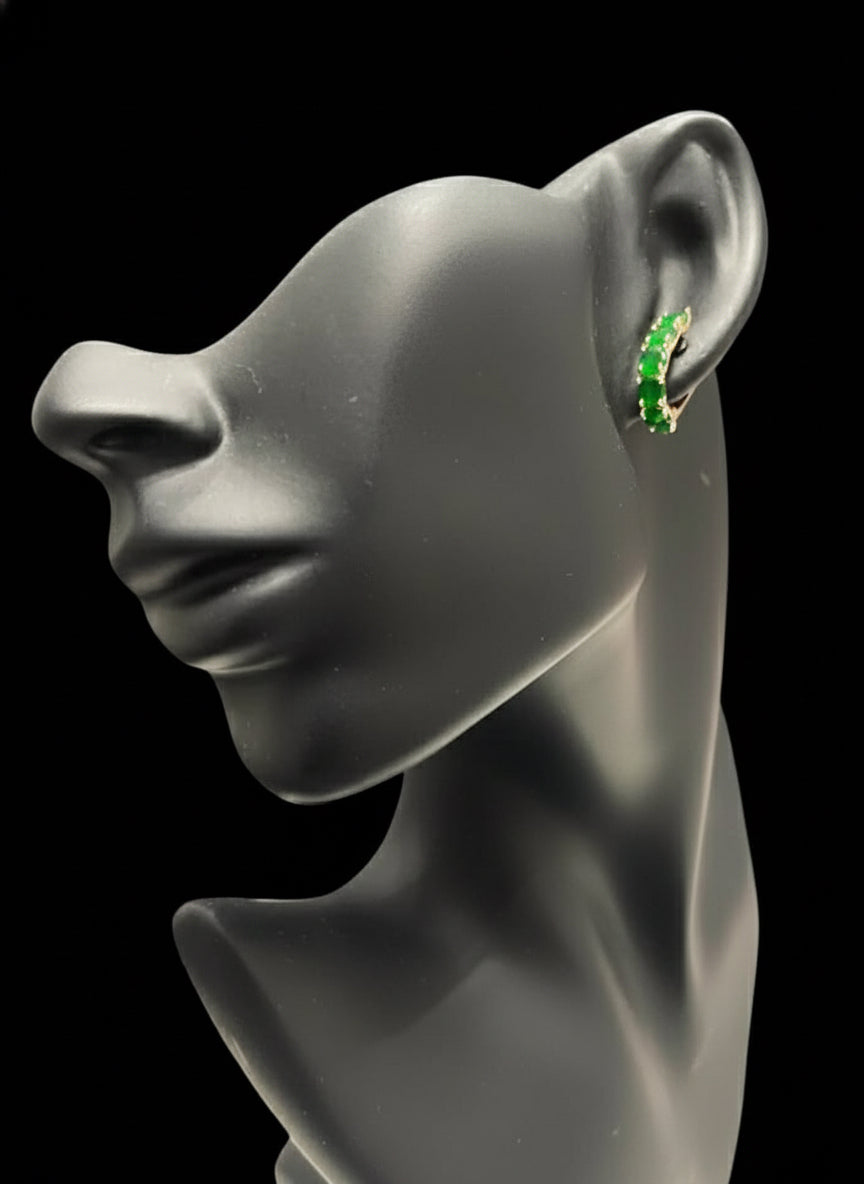 A 14k rolled gold emerald huggy hoop earring displayed on a mannequin, showcasing how it fits on the ear.