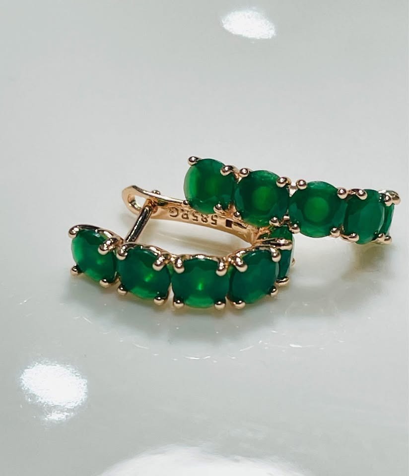 Top-down view of 14k rolled gold huggy hoops with natural emeralds, highlighting the design and 585RG stamp.