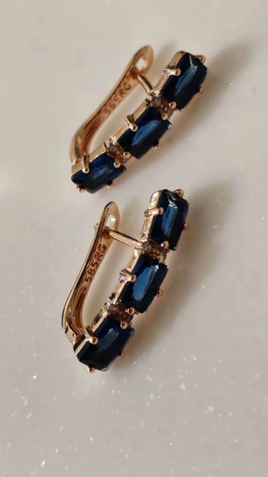 Vertical shot of 14K rose gold-filled bar earrings featuring three rectangular blue sapphires each.