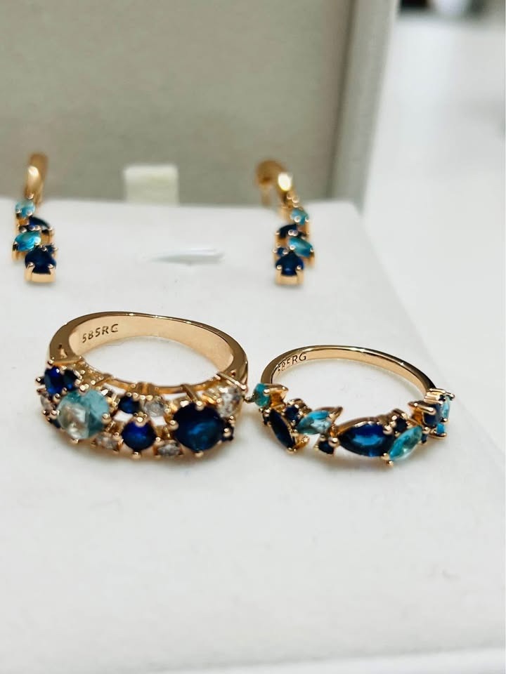  14k rolled gold set with two different rings and a matching pair of blue gemstone earrings.