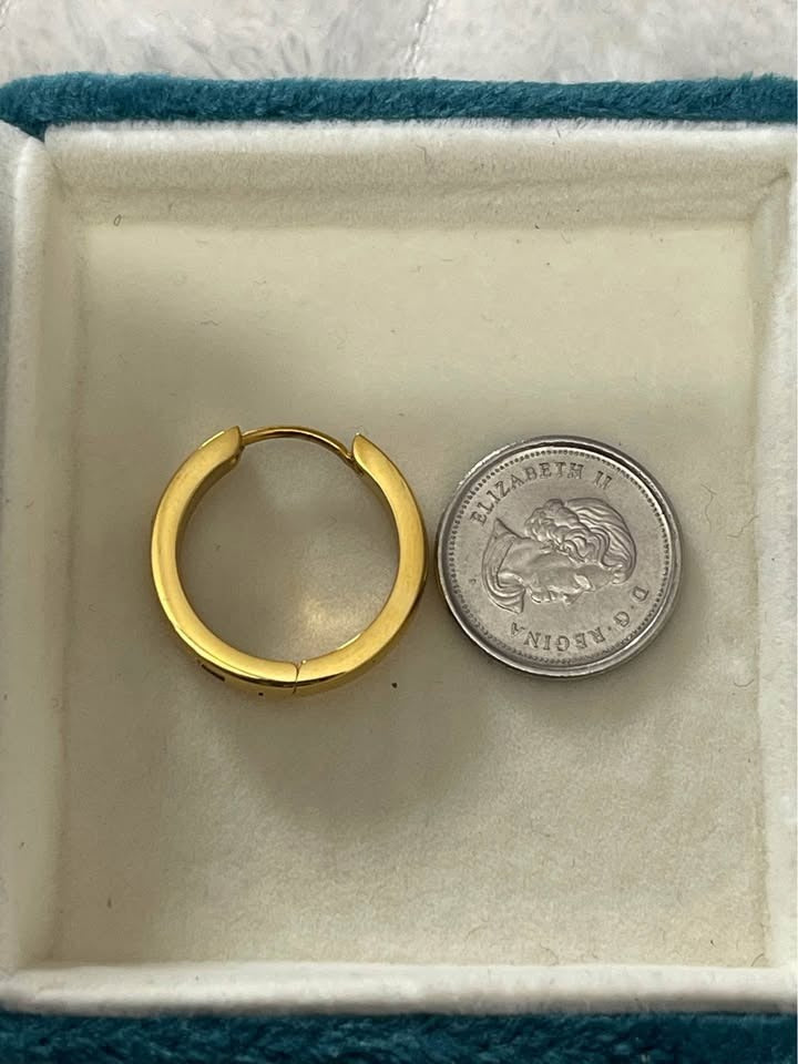 Size comparison of an 18K gold vermeil Julia hoop earring next to a Canadian coin in a jewelry box.