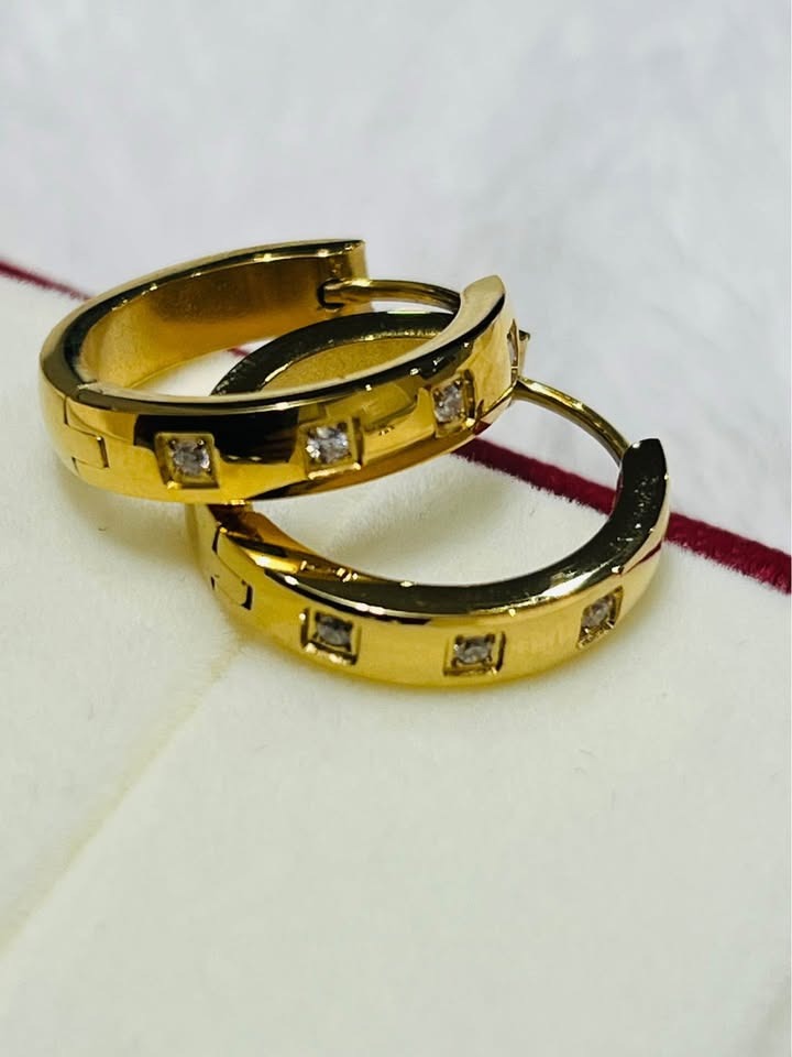 A close-up product shot of two 18K gold vermeil waterproof Julia hoops, showing off their design and finish.