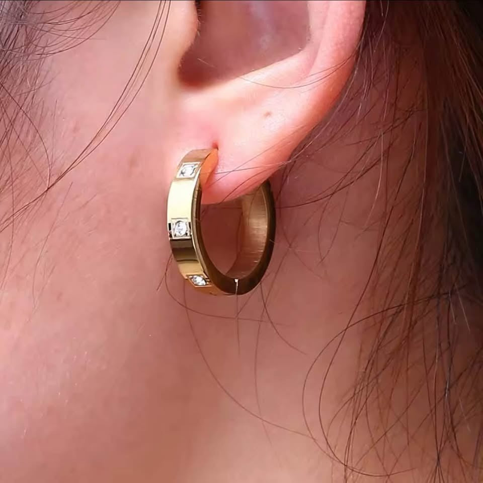 A close-up of an ear wearing an 18K gold vermeil Julia hoop earring with sparkling stone accents, perfect for daily wear.
