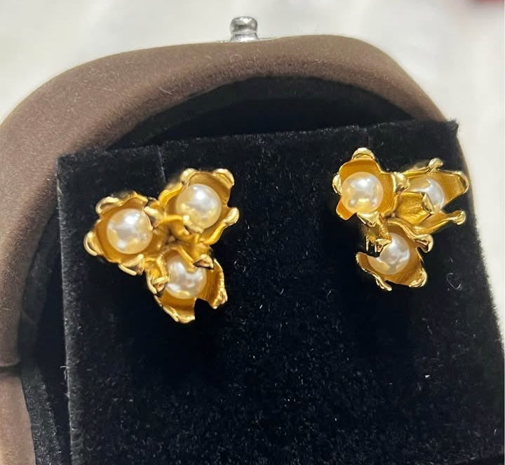 Angled view of 18k gold filled pearl tulip stud earrings, showcasing intricate details in a box.