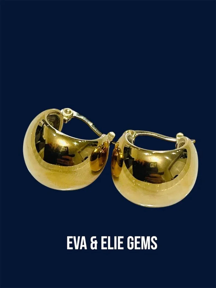  Pair of 18k gold-filled huggy hoop earrings on a dark blue background, highlighting the solid, shiny exterior.