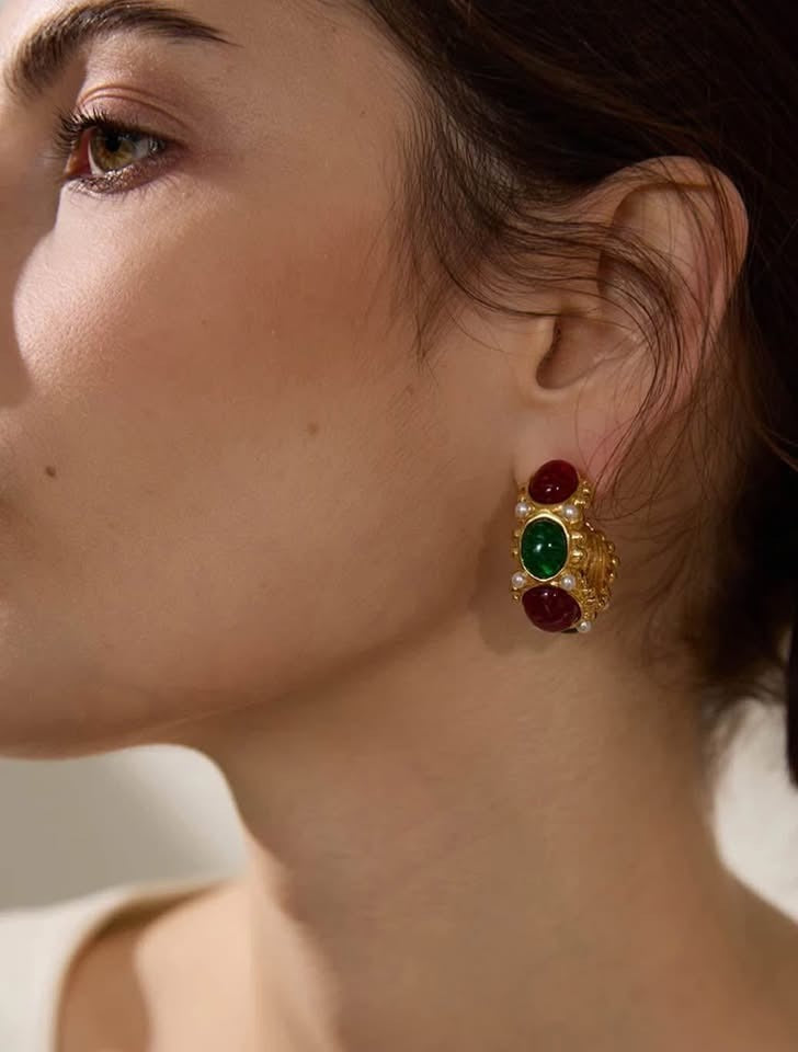 Close-up of an ear adorned with an 18k gold vermeil East West earring, featuring colorful gemstones and small pearls.