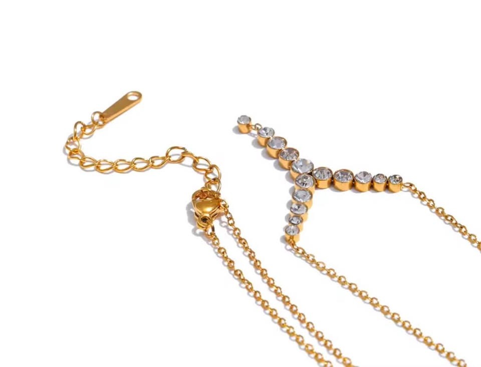 Close-up of an 18k gold-filled necklace, detailing the adjustable chain and lobster clasp with a part of the Y-design.
