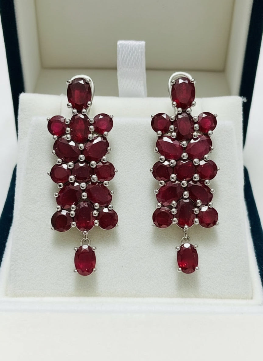 Front view of 20 CT genuine certified ruby dangle earrings, featuring multiple oval and round rubies.