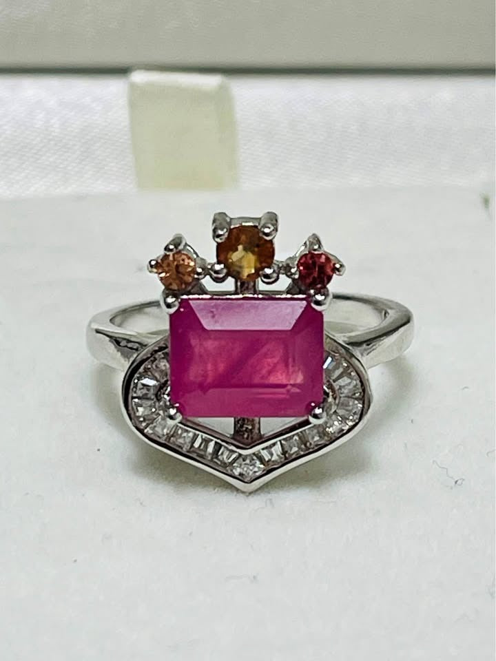 Close-up of a natural 3 carat ruby ring with multi-colored sapphires and diamond-like halo.