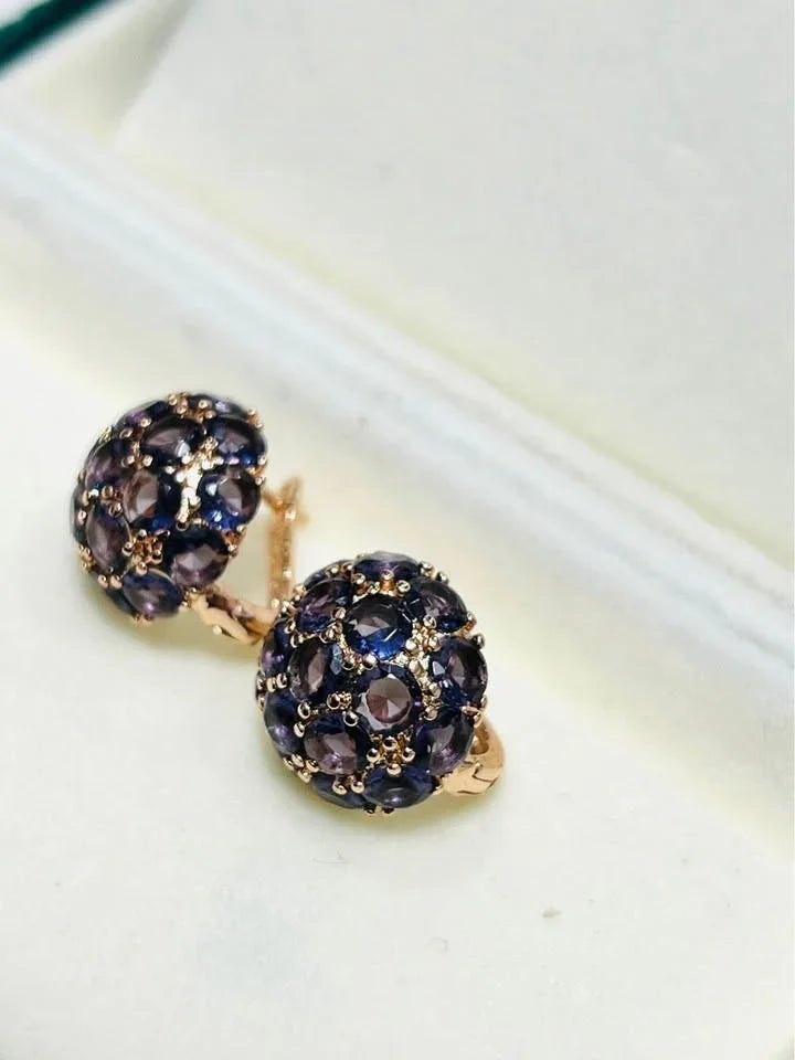 Angled view of elegant 585RG rose gold dome earrings, sparkling with numerous amethyst stones.