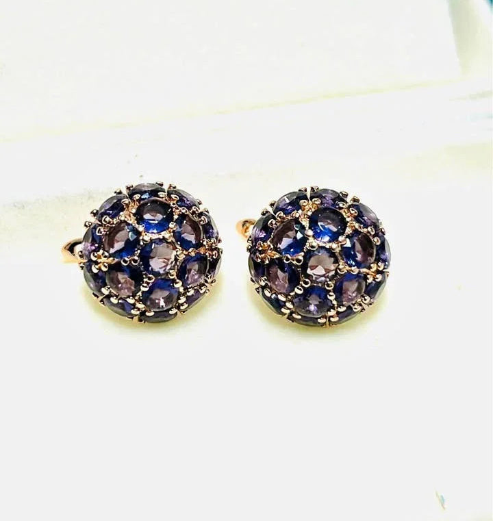 A pair of beautiful 585RG rose gold dome earrings with amethyst, displayed in a jewelry box.
