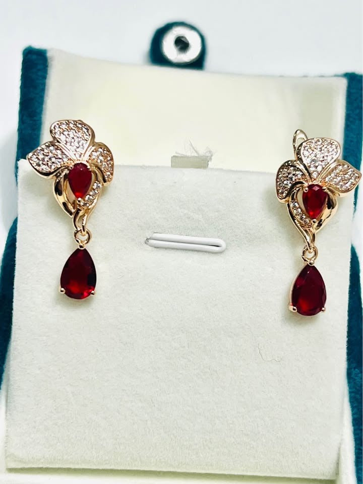 14k 585RG stamped red fancy dangle earrings displayed in a light-colored jewelry box.