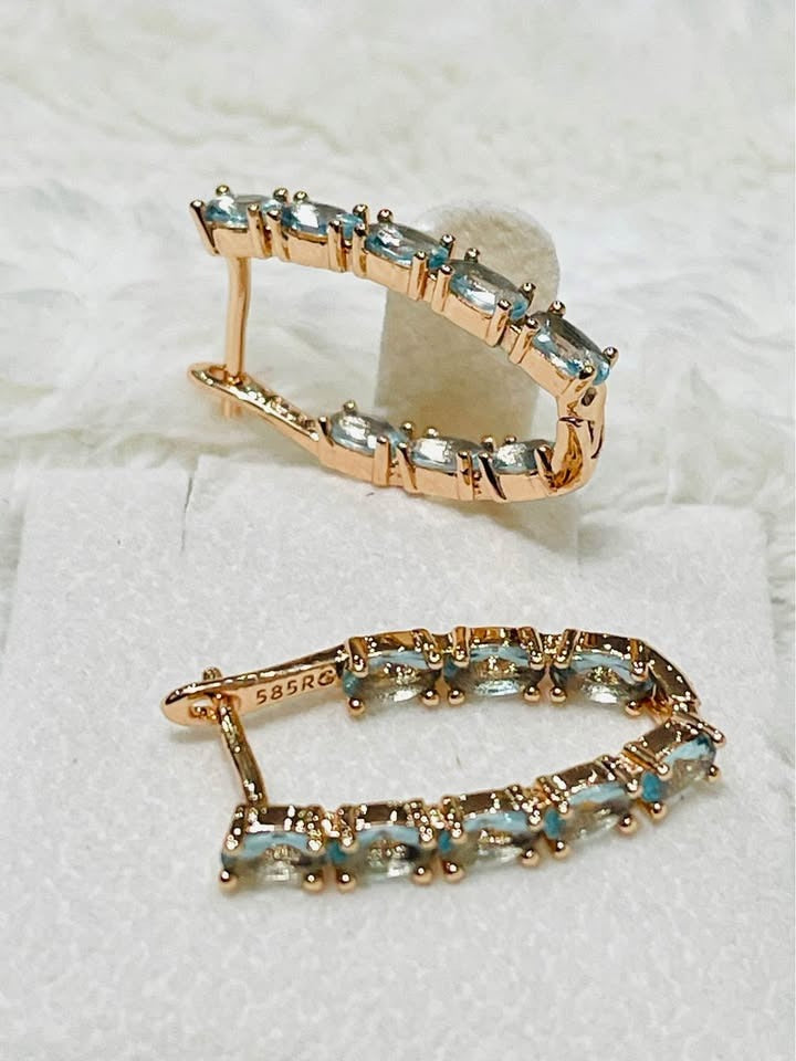 Close-up of 14k 585RG rose gold aquamarine inside-out hoops, highlighting the stamp and stones.