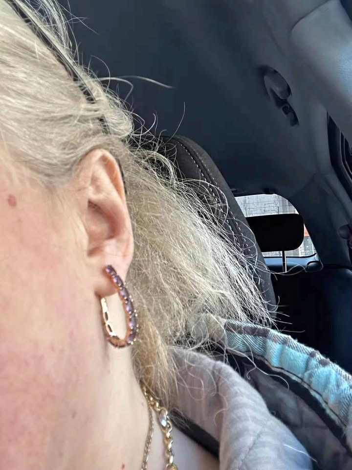 Woman wearing a 14K rose gold amethyst hoop earring, showcasing its size and fit on ear.