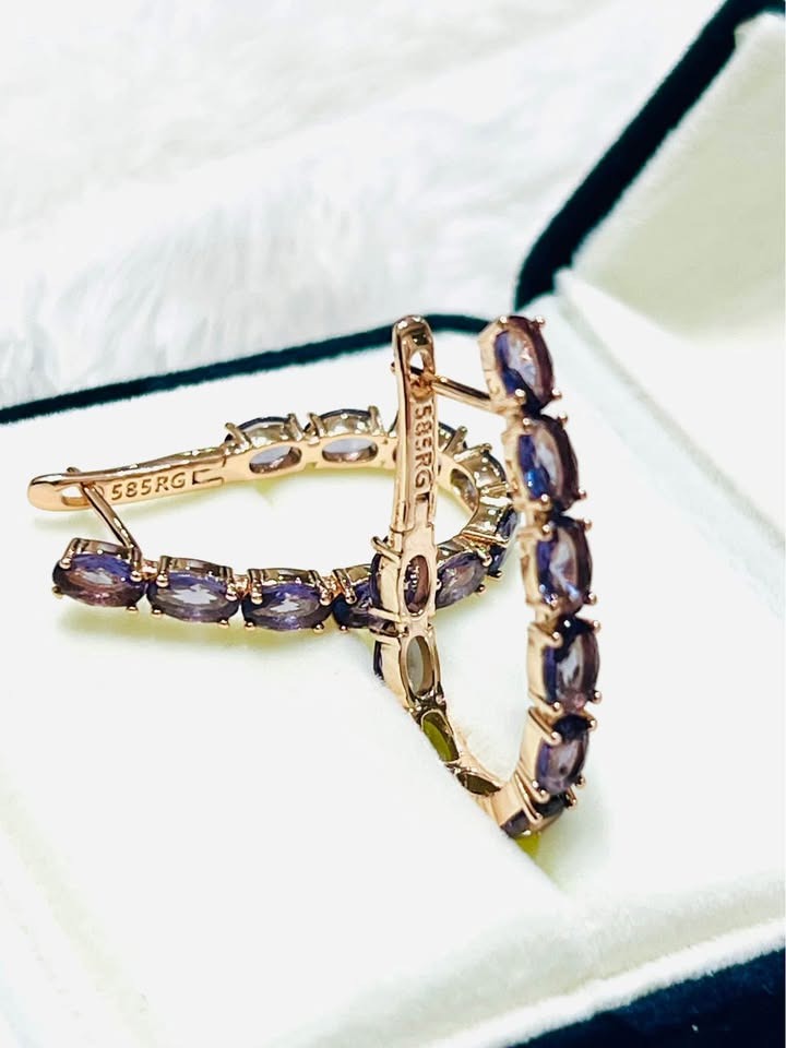  Two 14K rose gold (585RG) amethyst hoop earrings displayed in an open jewelry box.