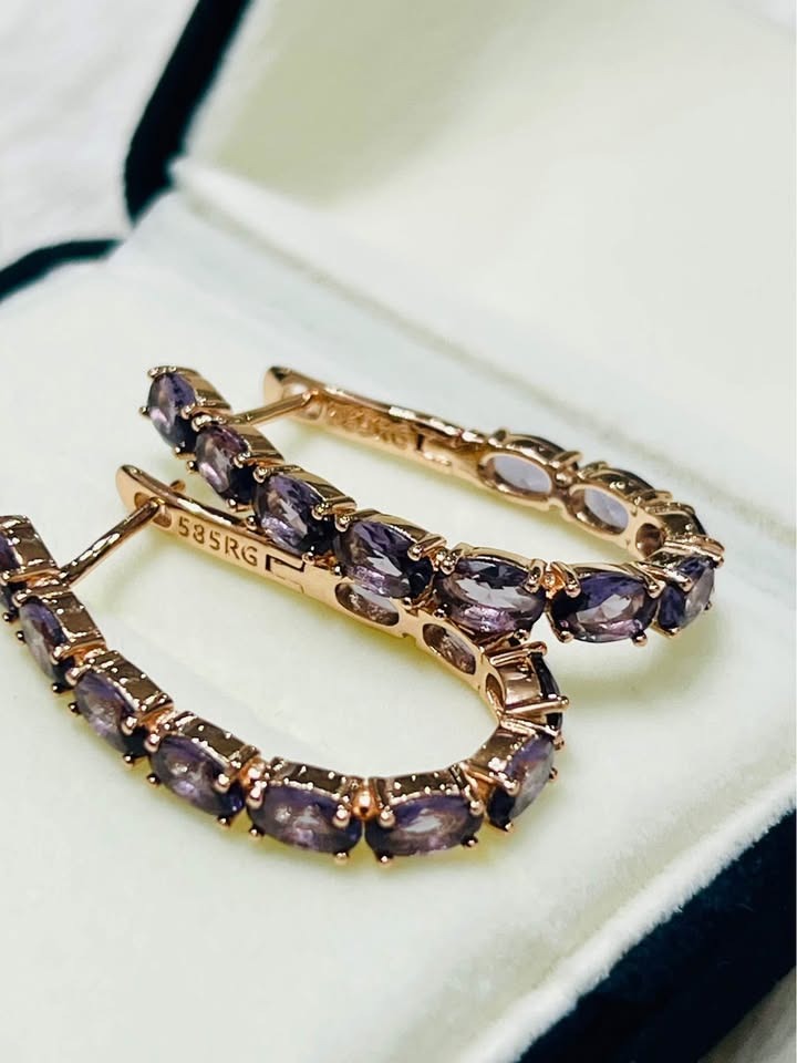 Close-up of 14K rose gold (585RG) amethyst hoop earrings nestled in a white jewelry box.