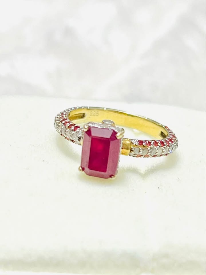  Angled view of a natural ruby and diamond ring with a pave band.