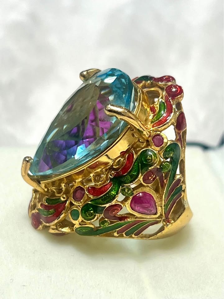 Close-up of a 22ct natural blue topaz antique ring, showing detailed red and green enamel.