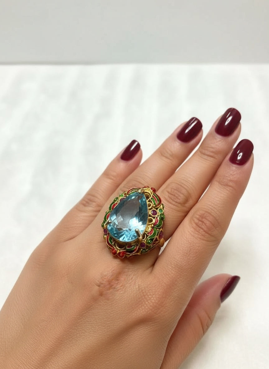 Side view of a 22ct blue topaz royal ring on a hand, highlighting its handcrafted enamel details.