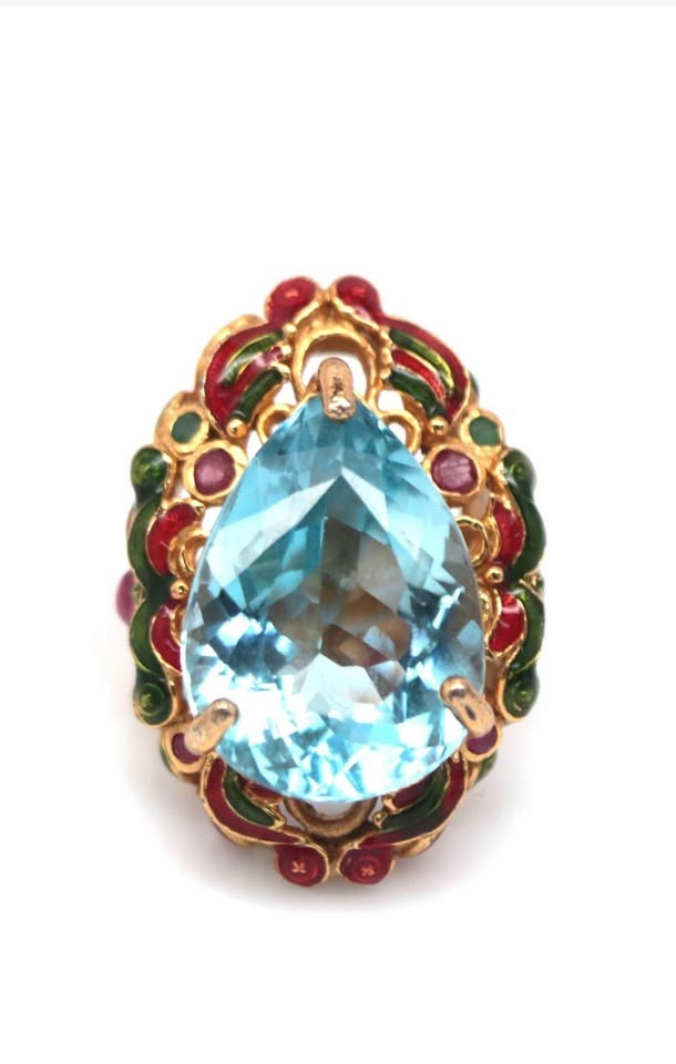 Studio shot of a 22ct natural blue topaz antique royal handmade ring with intricate enamel.