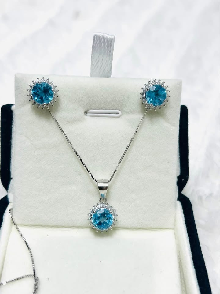 Elegant blue topaz halo jewelry set, including a necklace and earrings, presented in a gift box