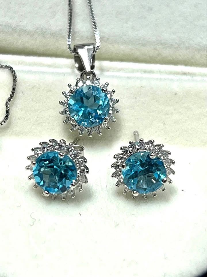 Complete blue topaz halo jewelry set: necklace and earrings in rhodium-plated sterling silver.