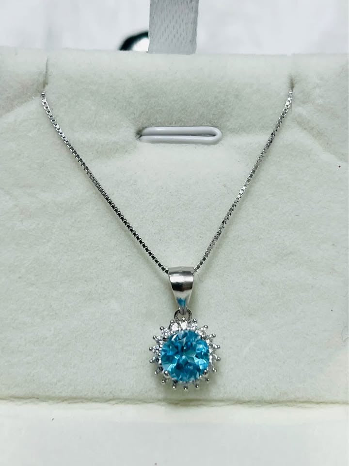 Beautiful blue topaz halo pendant necklace, showcasing the radiant gemstone on a silver chain.