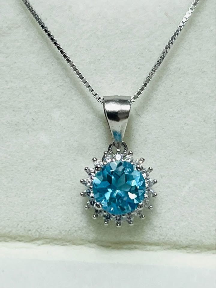 Exquisite round blue topaz pendant necklace with a brilliant halo, rhodium-plated sterling silver.