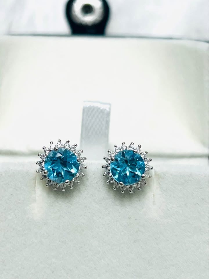 Pair of dazzling round blue topaz halo stud earrings, sterling silver, ideal for daily wear.